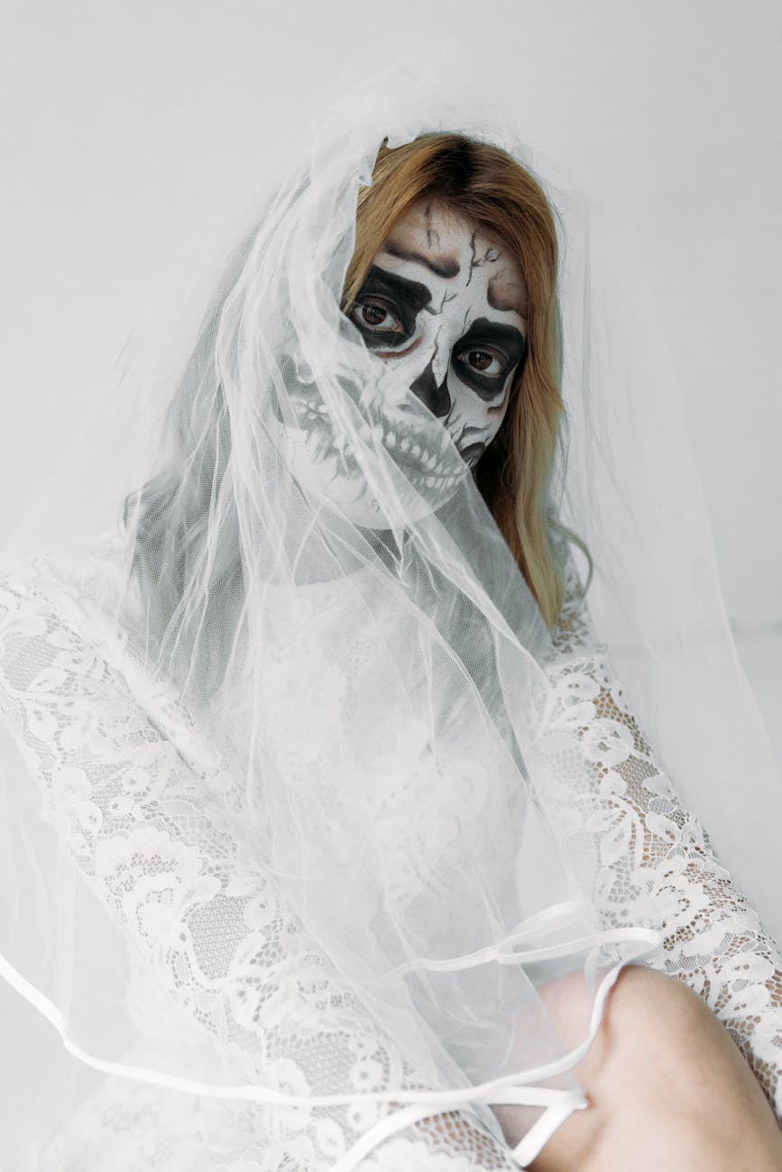 woman with face paint wearing a white veil